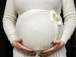 pregnant woman holding her tummy during daytime
